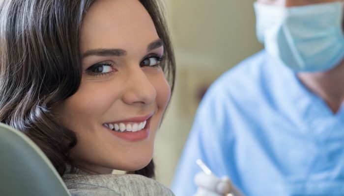 Smiling young woman receiving dental checkup
